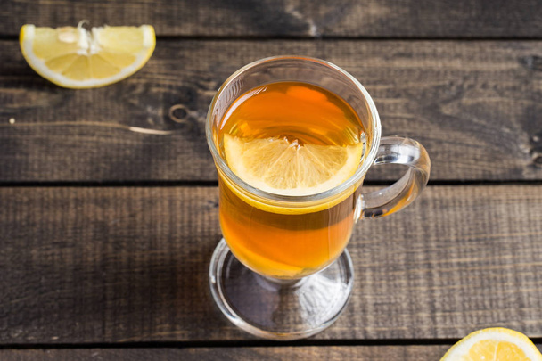 Чашка імбирного чаю з лимоном на дерев'яному фоні
. - Фото, зображення