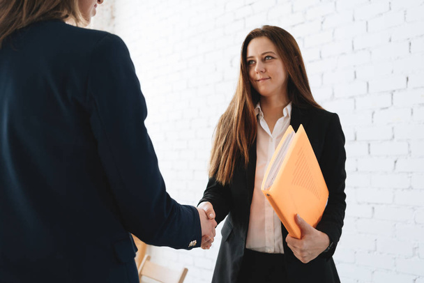 Photo of two womans handshaking process after success deal. Business female partnership handshake concept in coworking office - Φωτογραφία, εικόνα