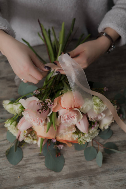 The florist girl packs a bouquet - Foto, afbeelding