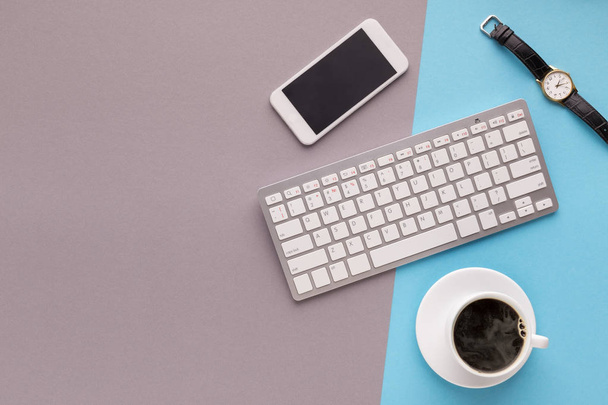 Desk with smartphone and keyboard on colourful background - Zdjęcie, obraz
