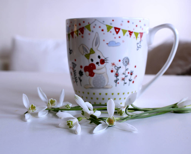 Горщик чаю і букет пролісок на білому тлі. Весняна композиція. Сплескний фон
. - Фото, зображення