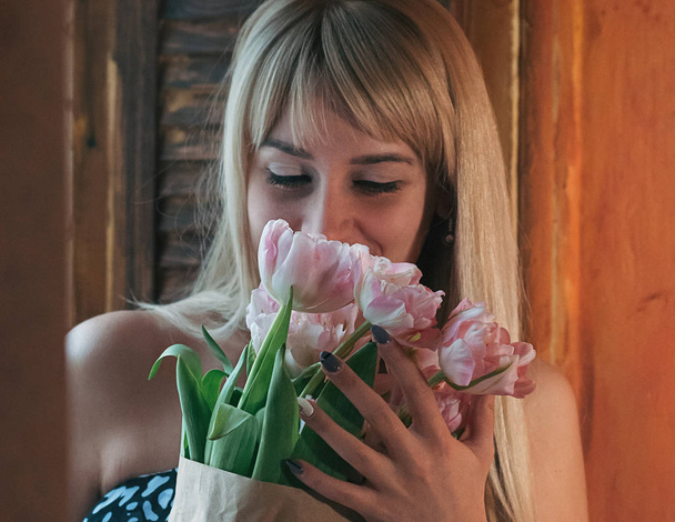 Розмитий образ молодої блондинки з квітами
  - Фото, зображення