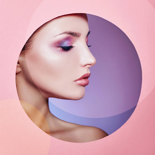 Beauty makeup cosmetics nature fashion woman in a round hole circle in pink paper, copy space advertising. Professional makeup perfect skin and shiny lipstick. Advertising banner, book cover. - Foto, imagen