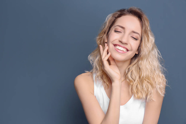 Young woman with beautiful smile on color background. Teeth whitening - Φωτογραφία, εικόνα