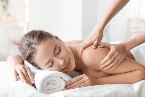 Young woman enjoying massage in spa salon - Valokuva, kuva