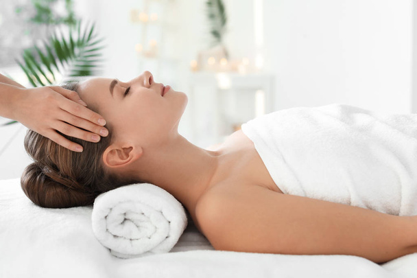 Young woman enjoying massage in spa salon - Foto, Imagen