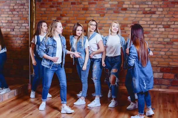 niñas en jeans en el fondo de la pared de ladrillo
 - Foto, imagen