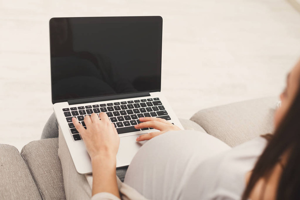 Ευτυχισμένη γυναίκα έγκυος χρησιμοποιώντας t φορητό υπολογιστή στο σπίτι - Φωτογραφία, εικόνα