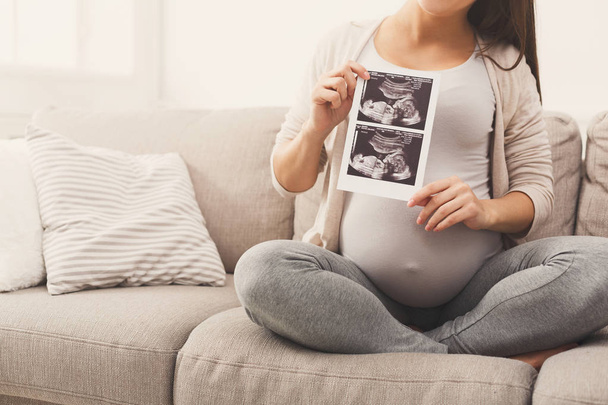 Schwangere schaut auf ihre Baby-Sonografie - Foto, Bild
