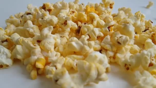 Popcorn vliegt op een witte achtergrond slow motion - Video
