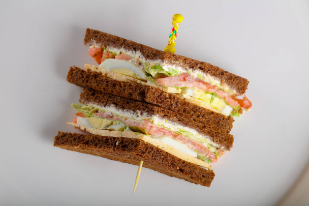 Sandwich club avec viande, fromage et légumes
 - Photo, image