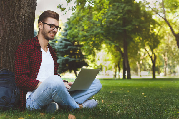 A smiling man with laptop outdoors - Photo, Image