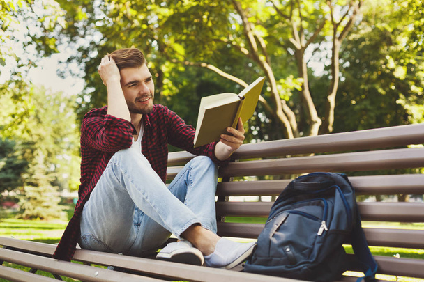 Young man reading a book outdoors - Photo, Image