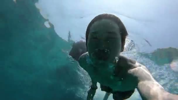 Jonge Aziatische man zwemmen onder de zee - Video