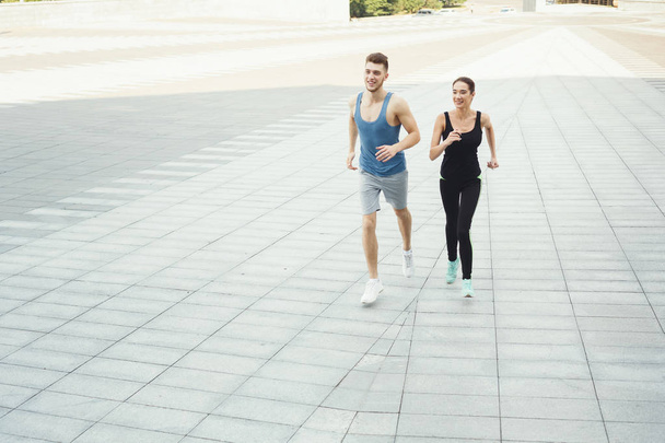 Young woman and man jogging in city copy space - Fotó, kép