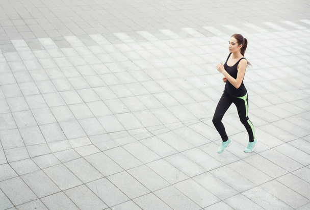 Jonge vrouw joggen in de stad kopie ruimte - Foto, afbeelding