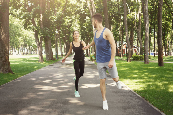 Fiatal pár, jogging zöld parkban, másol hely - Fotó, kép