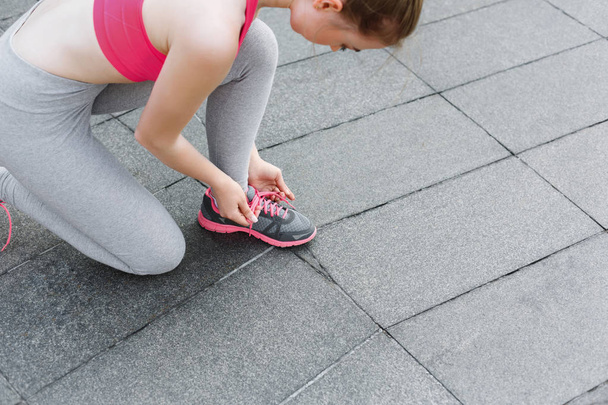 Нерозпізнана жінка зв'язує шнурки перед бігом
 - Фото, зображення