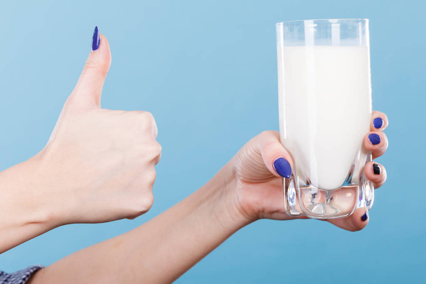 Woman hand holding glass of milk - Fotó, kép