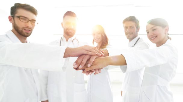 Artsen en verpleegkundigen in een medisch team stapelen handen - Foto, afbeelding