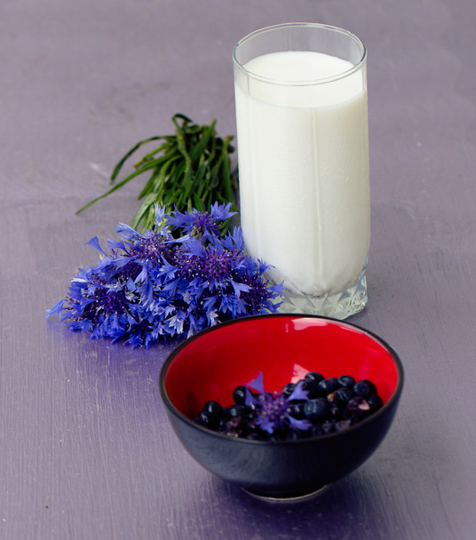 glass of milk and a bouquet cornflowers - 写真・画像
