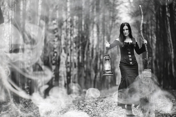 Woman in a witch suit in a dense forest - Photo, Image