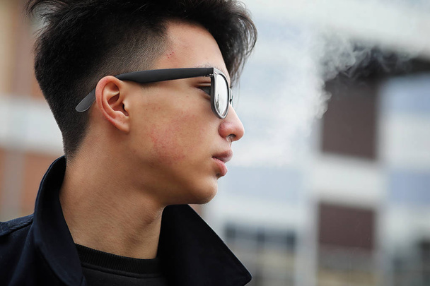 Asiático joven hombre fumar en la calle
 - Foto, imagen