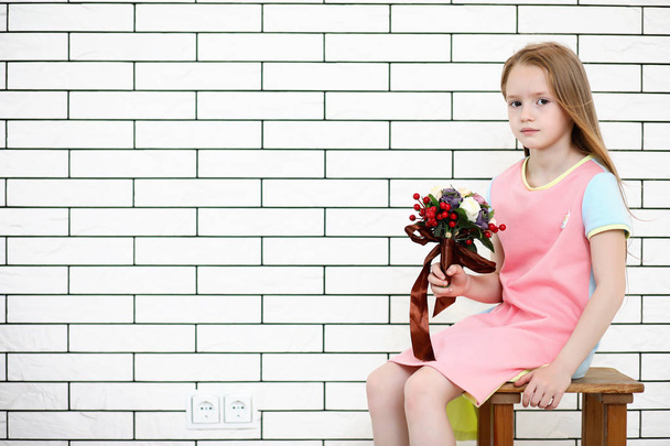 little girl is sitting on a chair - Фото, зображення