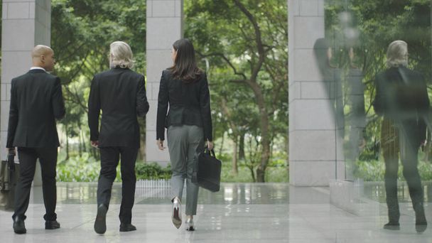 three business people walking out of modern office building - Photo, Image