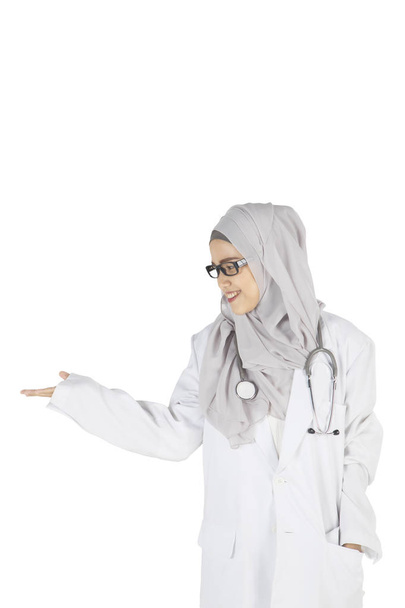 Pretty Muslim doctor showing something on studio - Foto, Bild