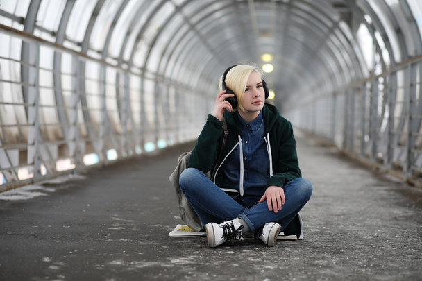 Młoda dziewczyna słucha muzyki w duże słuchawki w metrze - Zdjęcie, obraz