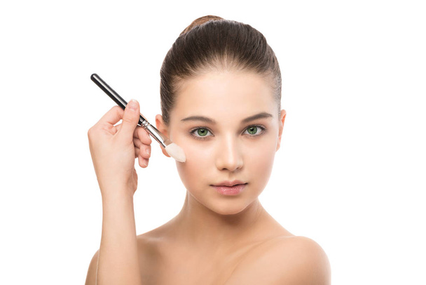 Young brunette woman with clean face. Girl perfect skin applying cosmetic brush. Isolated on a white. - Foto, Imagem