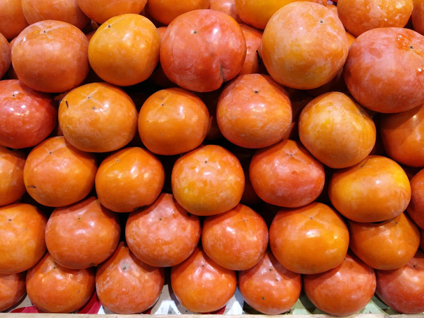 Органічні плоди хурми в купі на місцевому ринку фермерів
 - Фото, зображення
