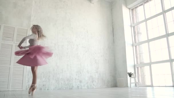 danser van het ballet draait tegen de achtergrond van een groot licht raam. Ballerina in een klassieke tutu en pointe. Slow motion - Video