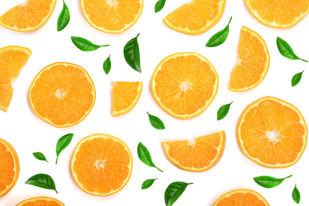 Slices of orange or tangerine decorated with green leaves isolated on white background, top view. Fruit composition - Photo, Image