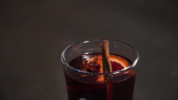 Hot red wine with fruits and spices in a glass. mulled wine - Πλάνα, βίντεο