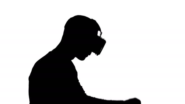 silhouette of a man in virtual reality glasses is dancing - Záběry, video
