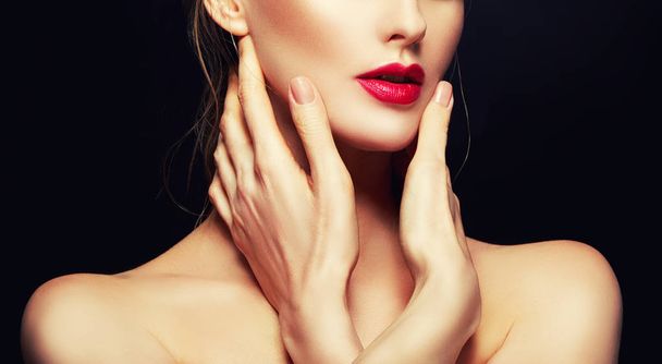 赤い唇と顔付近の手の女性の顔の部分的なビュー - 写真・画像