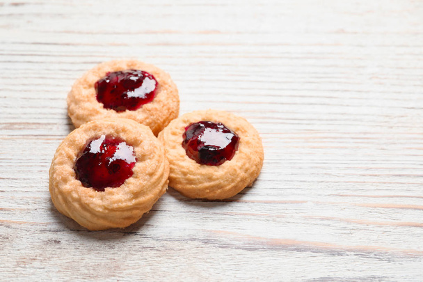 Tasty cookies with jam on wooden background - Foto, imagen