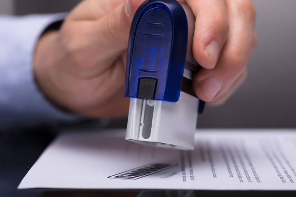 Close-up Of A Businessperson's Hand Stamping Document - Foto, afbeelding