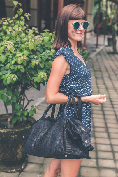 Fashionable woman with luxury snakeskin python handbag outside. Snakeskin fashion concept. - Photo, Image