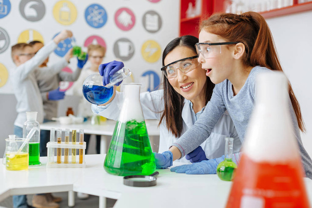 Upbeat teacher and student being excited about mixing chemicals - Foto, Imagem