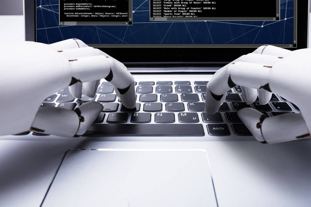 Close-up Of A Robotic Hand Typing On Laptop Keypad - Φωτογραφία, εικόνα