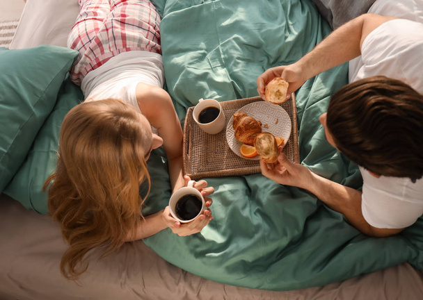 Young lovely couple having breakfast on bed - Foto, Imagem