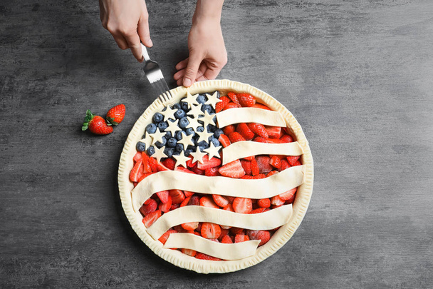 Woman preparing American flag pie on grey background - Foto, immagini