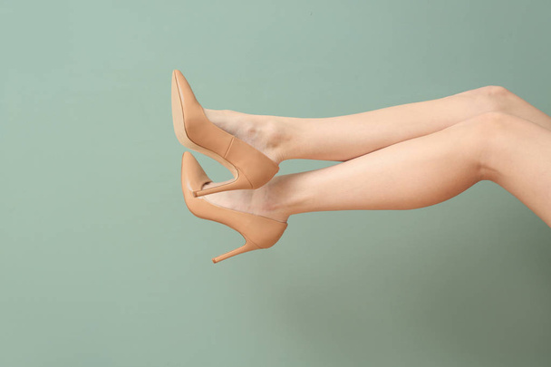 Legs of young woman in elegant shoes on color background - Fotografie, Obrázek