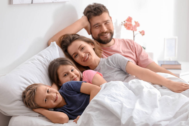 Hermosa mañana de familia feliz en el dormitorio
 - Foto, imagen