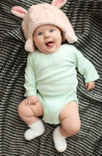 Little baby in cute hat lying on plaid, top view - Fotoğraf, Görsel
