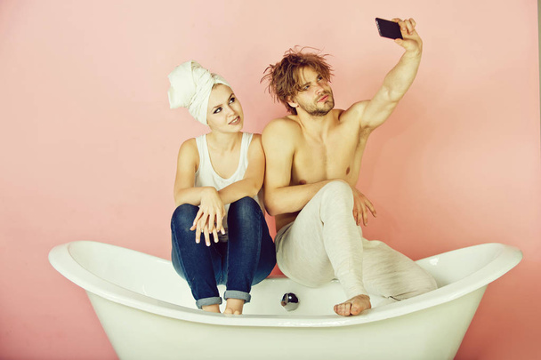 man and woman on bathtub with phone, couple in love - Fotó, kép