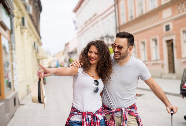 joven pareja de amor feliz viajando por la ciudad y tomados de la mano
 - Foto, imagen